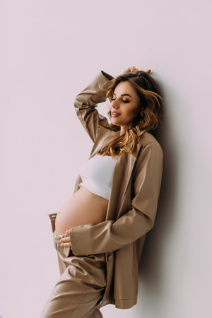 pregnant woman caressing her belly over white backgroundの写真素材