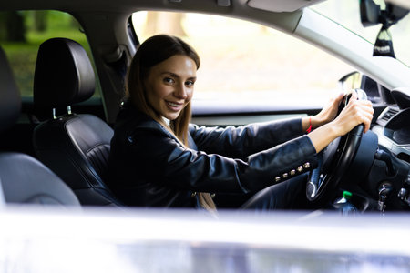Beautiful young happy smiling woman driving her car.の写真素材