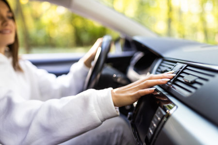 Woman finger pressing emergency button on car dashboard