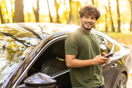 transport, people and technology concept - smiling indian man or driver using smartphone in car