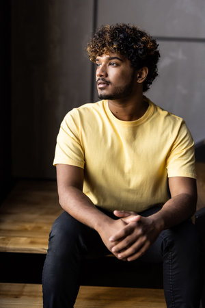 Low angle man sitting on stairs at homeの写真素材