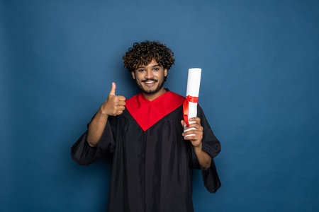 education, graduation and people concept - happy Indian Male graduate student in mortarboard and...