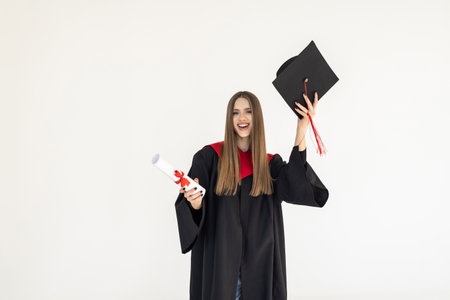 Happy graduate student woman in mortarboard and bachelor gown with diploma celebrating and making...