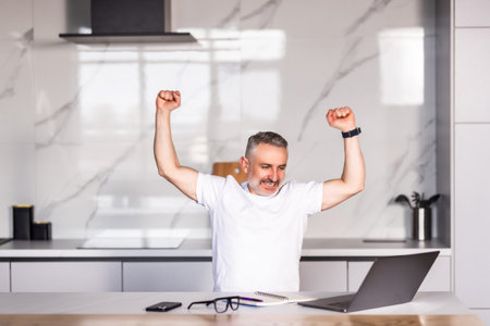 Happy excited old man winner excited by reading good news looking at laptop, overjoyed senior mature grandfather watching game online celebrating goal bid bet win great result victory conceptの写真素材