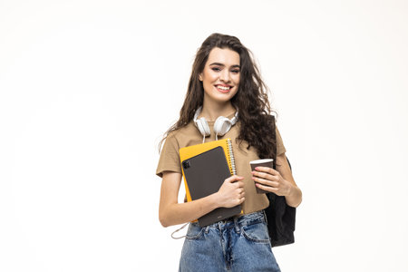Full length portrait of a smiling young teenage girl wearing backpack and holding pc tablet isolated over white backgroundの写真素材