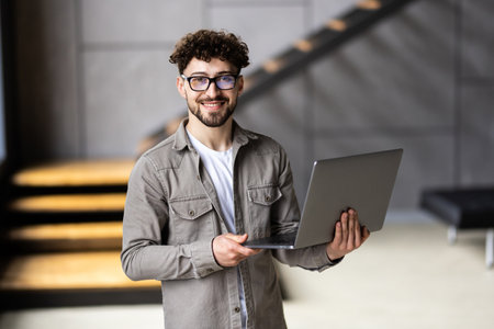 A happy manager ready to work from home on his laptop.の写真素材