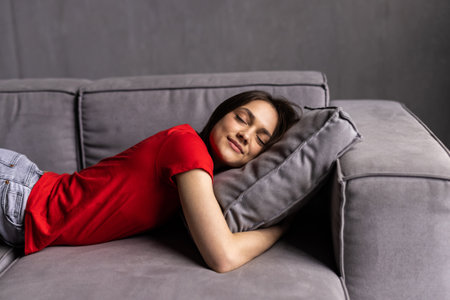 Happy woman lying on couch at home.