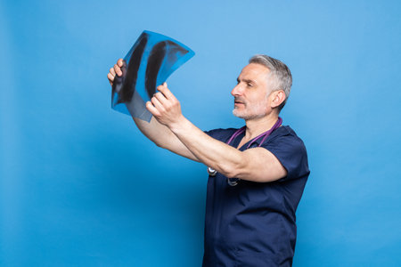 smiling doctor holds x-ray on blue background