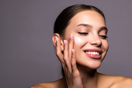 Face, beauty and satisfaction with woman in studio on a gray background to promote natural skincare.の写真素材