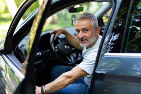 Man customer male buyer client in shirt get out car touch door look camera salon drive choose auto want buy new automobileの写真素材