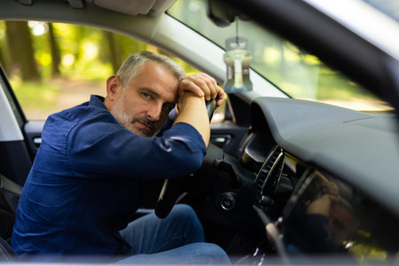 Young man sitting inside car is very upset and stressed