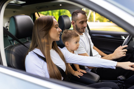Happy family riding in the modern car. Couple with a little son on the backseat. Family values and car traveling concept.の写真素材