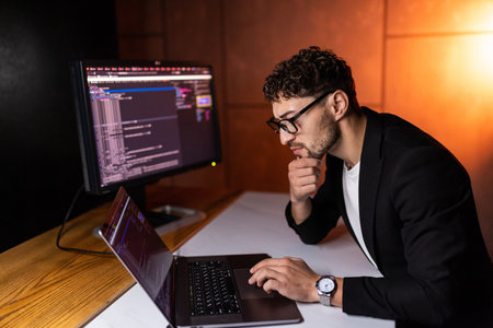 Laptop, screen and business man for coding, software development and programming script in cybersecurity. Night, computer research and programmer or IT person with html code, system or data analysisの写真素材