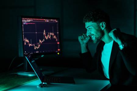Cheerful broker celebrating exchange market achievement, feeling happy about financial win and forex trade victory. Enjoying stock banking and money success on laptop. Handheld shot.の写真素材