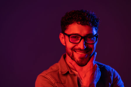 Neon studio portrait of serious man model with mustaches and beard in sunglasses and white t-shirt