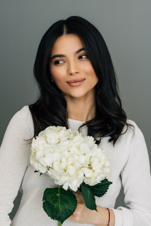 Young woman hold hydrangea flower bouquet on white background.
