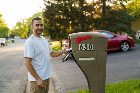 A man getting his mail from his mailbox.