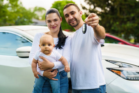Young family with little child show key of their new car