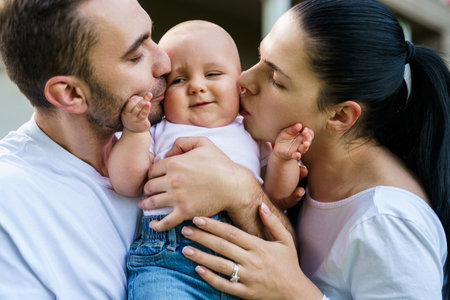 Parents kiss kid and happiness playing in green grass at home. Family spending time together...