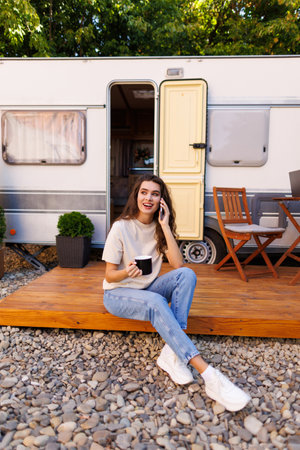 Young woman traveling alone in motor home rv talking on smart phoneの写真素材