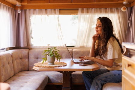 Young woman working on laptop in camperの写真素材