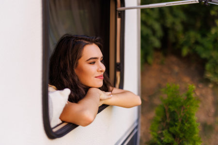 Caucasian woman peeking out of camper window.の写真素材