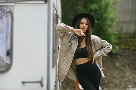 Pretty woman on a road trip with her camper- taking a break at sunset