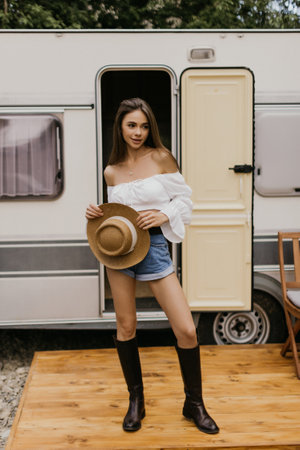 Happy woman standing near camper vanの写真素材