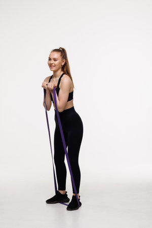 Fitness woman using resistance band in her exercise routine. Photo of fitness woman doing fitness...