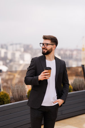 Take a pause. Waist up portrait of smiling businessman while having coffee break on office balconyの写真素材