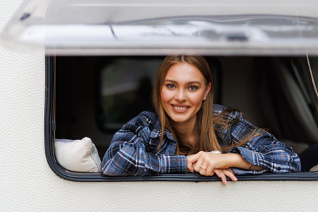 Happy tourist enjoy parking destination opening the window of a modern camper van and looking...