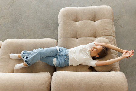 Top view happy young woman relaxing on couch at home,の写真素材