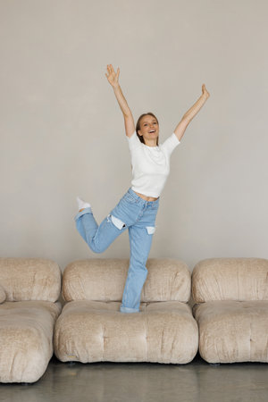 Young woman jumping on the sofa at home.の写真素材