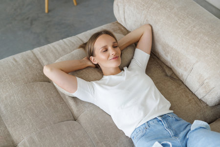 Top view of a beautiful and happy young woman lying on a sofa