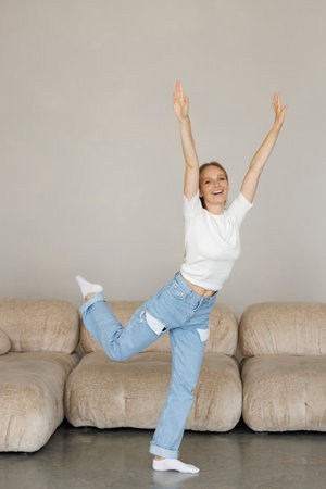 Young woman jumping on the sofa at home.の写真素材