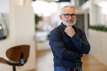 Serious mature 45 years old business man investor standing in office looking away.