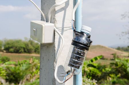 electricity switch in the plastic bottle cover to protect it from rainingの写真素材