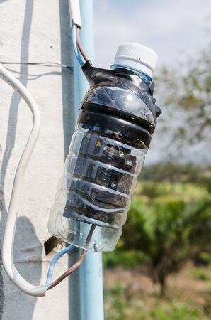 electricity switch in the plastic bottle cover to protect it from rainingの写真素材
