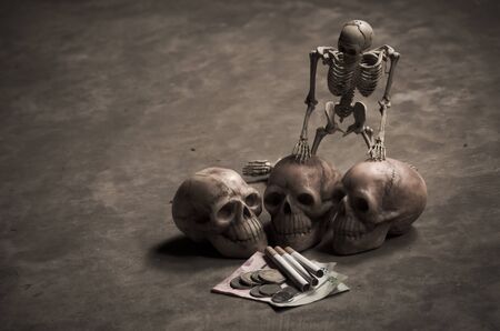 still life style of skull with losing money of cigarette