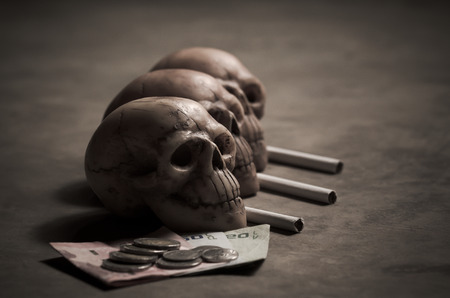 still life style of skull with losing money of cigaretteの写真素材