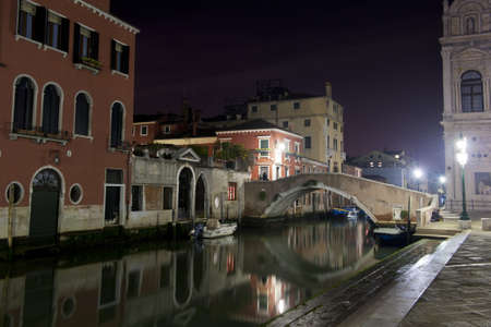 Night view of the bridge and the palaces facing the scuola grande di san marco and the basilica of giovanni and paolo in veniceの写真素材