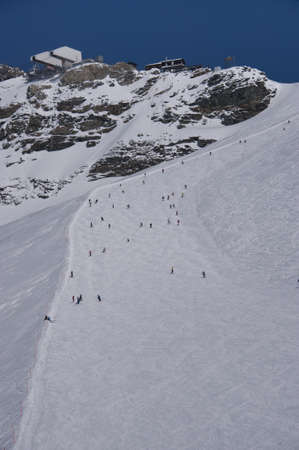 skiers on the black slope ventina, leaving from the plateau rosaの写真素材