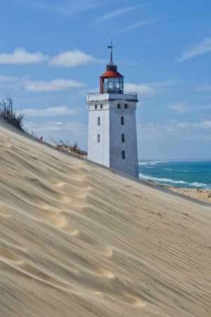 Lighthouse on a sand dune in Rubjerg Knude in Denmarkの写真素材