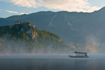 Silhouette of a boat near the Bled Castle overlooking the lake in Sloveniaのeditorial素材