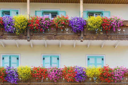 Colorful wood balcony full of flowers in bloom in Fassa Valleyの写真素材