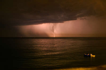 Lightning during a night thunderstorm on the summer ligurian seaの写真素材