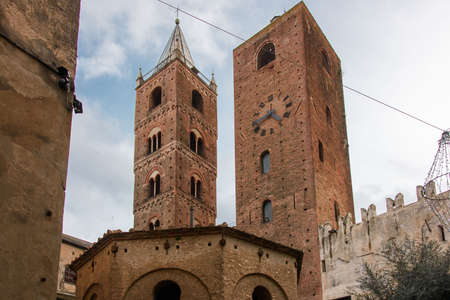 The belfry of the Cathedral and the Clock Tower, medieval landmarks in the old town of the ligurian village of Albengaの写真素材