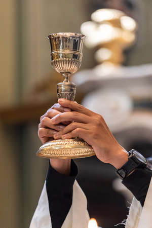 The elevation of the Goblet with the sacramental wine during the Catholic Liturgy of the Eucharistの写真素材