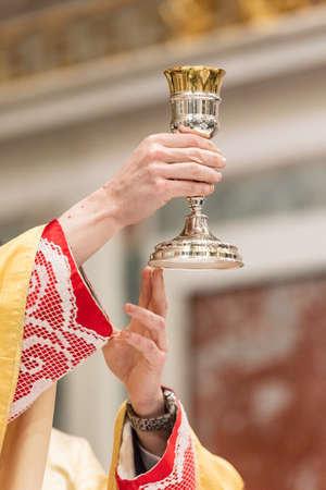 The elevation of the Goblet with the sacramental wine during the Catholic Liturgy of the Eucharistの写真素材