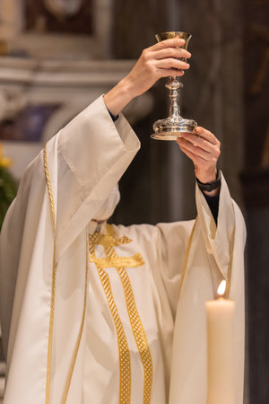 The elevation of the Goblet with the sacramental wine during the Catholic Liturgy of the Eucharistの写真素材